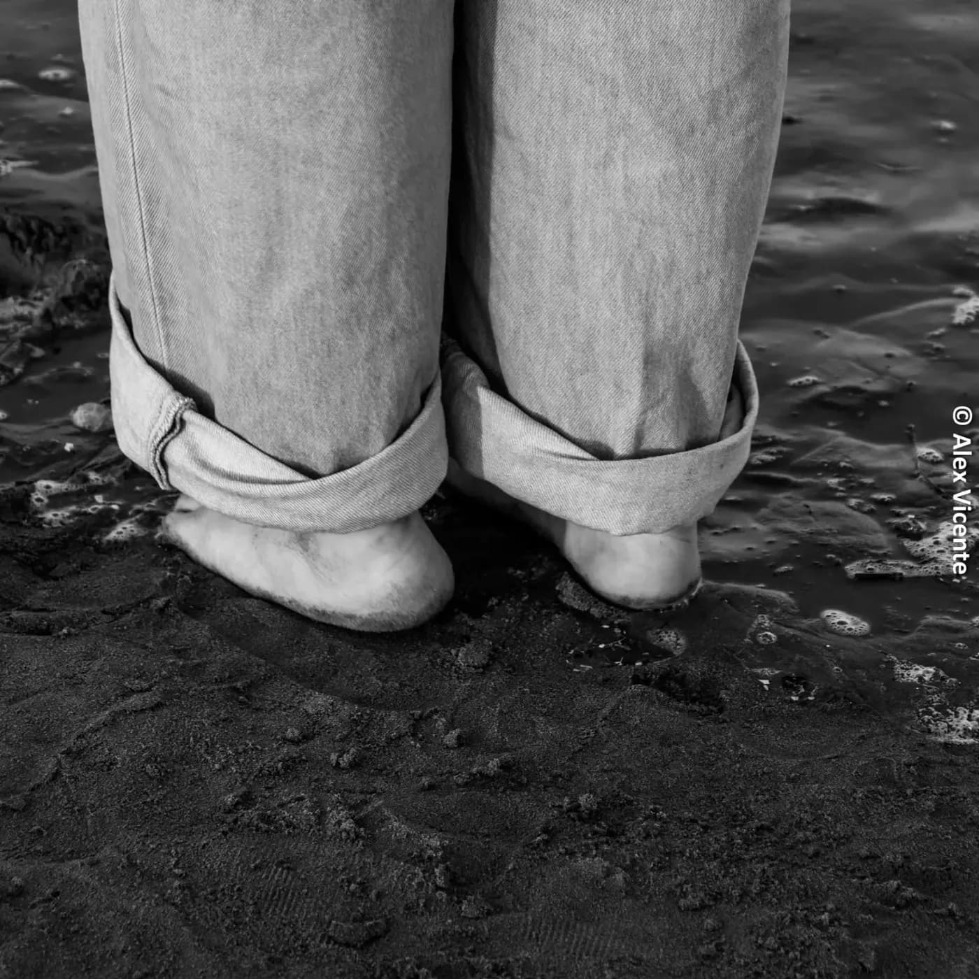 Bare feet by the water in black and white